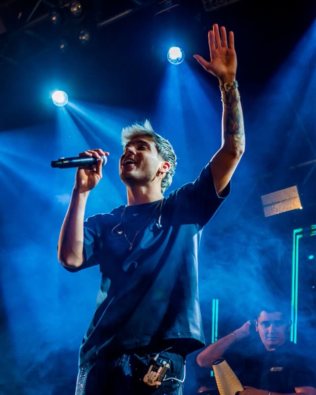 Cantante de DesaKTa2 con el brazo en alto bajo las luces